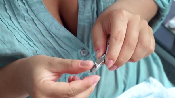 Žena stříhání kůžičky, zatímco domácí manikúru zblízka. Manikúry a nehtové péče koncept. Žena pomocí pinzety pro domácí manikúru. — Stock video