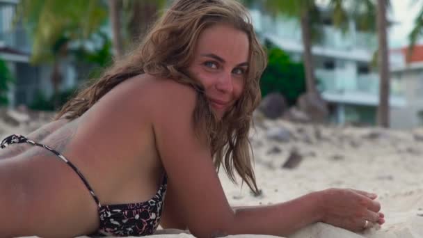 Yaz tatili sırasında kumsalda güneşlenme mutlu bir kadın. Yaz plaj üzerinde gülüyor ve kamera seyir gülümseyen kadın portre. — Stok video