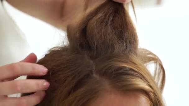 Haarstylist kapsel met bouffant maken en vouw voor jonge vrouw met lang haar. Kapper doet kapsel voor vrouw in kapsalon dressing. — Stockvideo