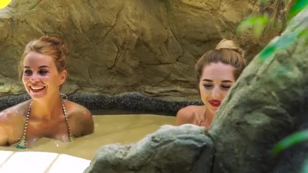 Deux jeunes femmes prenant un bain de boue dans un spa de luxe. Femme heureuse se détendre et profiter d'un bain dans un spa de boue pour la thérapie corporelle. Soins du corps et thérapie de la peau concept . — Video