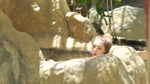 Relaxing woman lying in mud bath on luxury spa center. Young woman taking mineral bath and resting in spa resort. Body therapy and skin care concept. Healthy lifestyle. — Stock Video