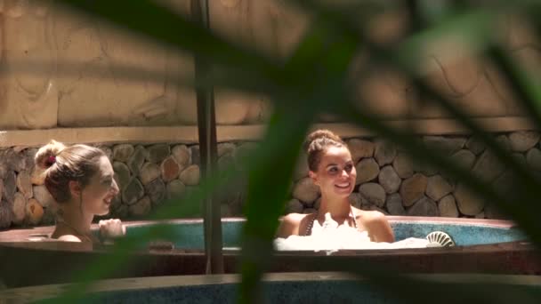 Mulher feliz tomando banho de jacuzzi no centro de spa de luxo. Mulher sorridente relaxante e desfrutar de banho no spa jacuzzi para cuidados com o corpo. Cuidados com a pele e terapia corporal. Conceito de beleza . — Vídeo de Stock