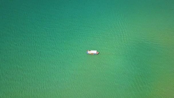 Рыбацкая лодка, плывущая в голубом море. Воздушный ландшафт летающего беспилотного судна, плавающего в прозрачной бирюзовой воде океана . — стоковое видео