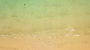 Kumlu plaj dron şeffaf su dalgalar deniz görüntüleyin. Kumlu sahilde sıçramasına üstten görünüm açık okyanus dalgaları. Boş ve vahşi beach.