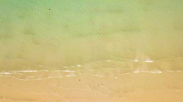 Sea waves of transparent water on sandy beach drone view. Top view clear ocean waves splashing on sandy shore. Empty and wild beach. — Stock Video