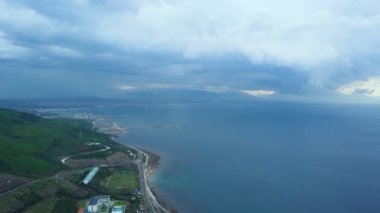 Güzel manzara deniz ve karayolu uçak uçan görüntüleyin. Havadan görünümü araba Otoban geçmiş deniz kıyısında ve yeşil tepeler.