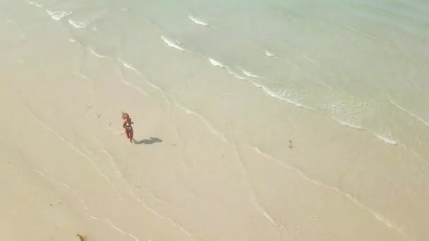 Belle femme en bikini courant sur de l'eau de mer transparente sur une plage de sable vue aérienne. Fitness femme courir vide mer plage drone vue .