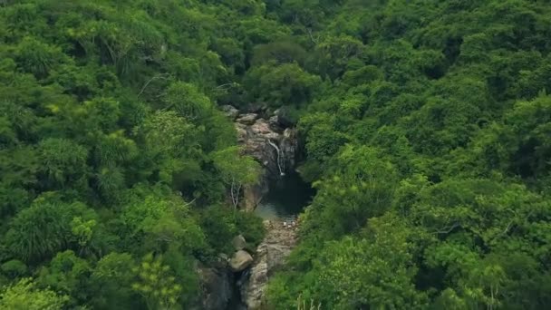 Felsiger Fluss mit Wasserfall in der Luftlandschaft des Tropenwaldes. Gebirgswasserfall und steiniger Fluss im Regenwald-Drone-Blick. Wilde Naturlandschaft — Stockvideo