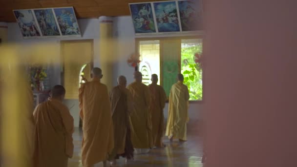 Hanoi, Vietnam - heinäkuu 2018: Buddhalaiset munkit oransseissa vaatteissa rukoilemassa buddhalaistemppelissä. Man munkit rukouksen aikana ja meditaatio buddhalainen pagodi — kuvapankkivideo