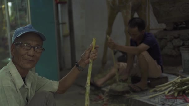 Ханой, Вьетнам - июль 2018 года: Портрет вьетнамца с палкой сахарного тростника в деревне. Лицо старика улыбается и смотрит в камеру . — стоковое видео