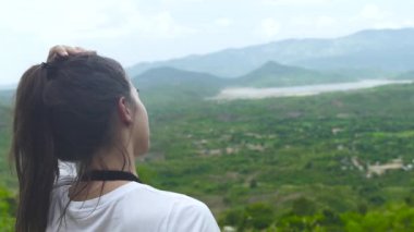 Kadın gezgin yeşil tropikal ormanda yukarıdan manzara seyir dağ tepe üzerinde. Genç kadın esmer saç dokunmadan