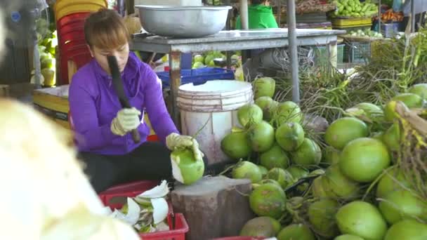 Hanoj, Vietnam - červenec, 2018: žena pomocí nůž na loupání zralé kokosové. Asijské žena loupání čerstvý kokos pro pití šťávy. — Stock video