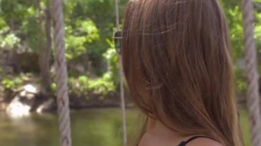 Yüz yung kadın güneş gözlüğü ve kahverengi saç yakın çekim. Oturan portre çekici kadın yaz aylarında bahçe salıncak.