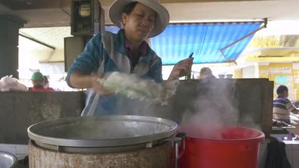 Hanoj, Vietnam - červenec, 2018: Asijské žena ležící horké rýži v misce po vaření. Žena uvedení připravené rýže. Vaření potravin na vietnamský trh. — Stock video