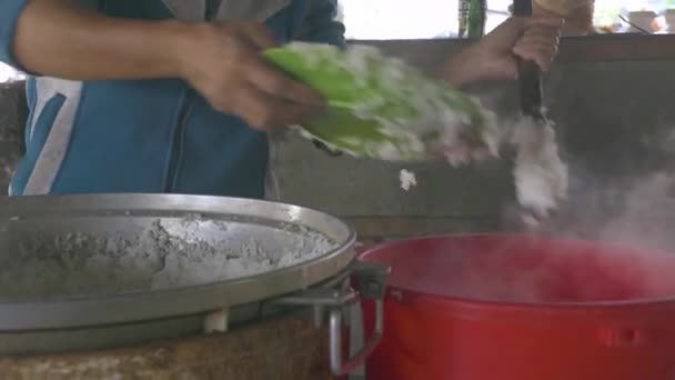 Female hands laying hot rice in bowl after preparing. Woman cooking rice in large saucepan. — Stock Video