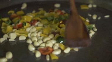 Şef yemek sarımsak ve biber sıcak tava üzerine kapatın. Lokanta mutfağı gıda hazırlama işlemi. Yemek sebze sarımsak ve Bulgar biber yağı tava, pilaki.