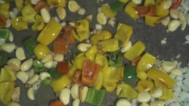 Garlic and peppers frying in olive oil on hot pan top view. Close up garlic, bulgarian pepper and onion cooking at pan. Process stewing vegetable in restaurant kitchen — Stock Video