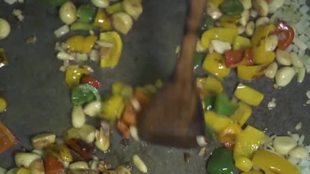 Cook Matlagning vitlök och paprika i olivolja på het panna ovanifrån. Närbild av vitlök och lök bulgariska peppar stewing på pannan. Processen förberedelse grönsak i restaurangkök. — Stockvideo