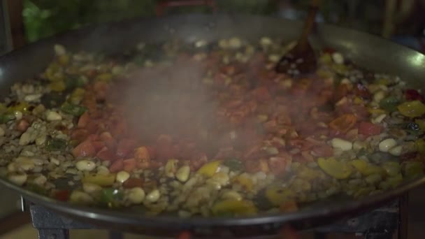 Las verduras frescas se fríen en aceite de oliva en la sartén caliente de cerca. Tomates, ajo, cebolla y pimienta bulgara cocinando en la sartén. Proceso de guisado vegetal en la cocina del restaurante . — Vídeos de Stock