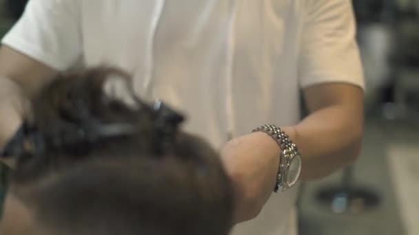 Перукарня для різання волосся з електричною бритвою в чоловічому салоні. Крупним планом чоловіча зачіска з використанням електричного бритви. Чоловіча стрижка з машиною для волосся в перукарні . — стокове відео
