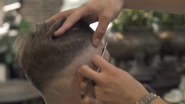 Barber afeitarse la cara con afeitadora recta, mientras que el peinado hipster en el salón de peluquería. Primer plano de afeitar el cabello en la cabeza con maquinilla de afeitar en el salón masculino. Manos de hombre usando navaja de afeitar para el peinado masculino . — Vídeo de stock