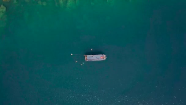 船在蓝海泻湖航行, 人们在清澈的水面上游泳。无人机查看海上帆船和人们沐浴在蓝色的水。空中风景. — 图库视频影像