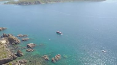 Mavi deniz suyu ve insanlar temiz su hava görünümünde yüzme yelken tekne. Deniz Körfezi ve dağ uçurumun kıyısında uçan Yelkenli tekne robot. Üstten görünüm mavi lagün.