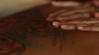 Masör vücut masaj yağı spa salonda işi kapatın. Vücut masaj ve spa bakım kavramı. Kadın cilt zekâ dövme.