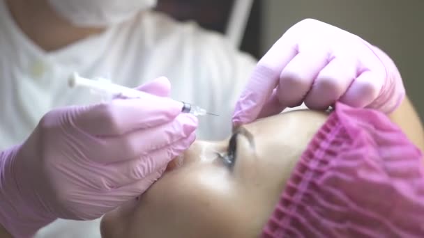 美容師は、美容クリニックで女性の顔に美容注射を行います。化粧品の注入を得る若い女性を閉じます。抗加齢、抗しわや顔のスキンケア。形成外科クリニック. — ストック動画