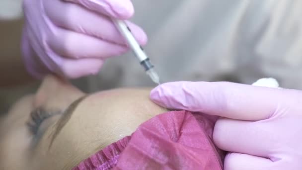 Médecin cosmétologue faire des injections rajeunissantes pour resserrer et lisser les rides sur le visage féminin. Gros plan femme obtenir une injection de beauté dans la clinique cosmétique. Concept de peau de cosmétologie . — Video