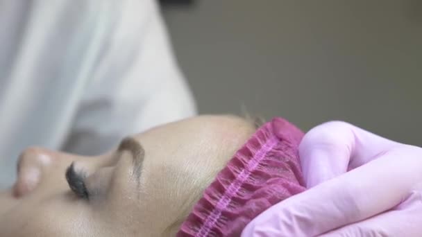 Cosmetólogo limpiando con algodón cara paciente en clínica de belleza. Mujer cercana que recibe procedimientos cosméticos y terapia de belleza. Cuidado facial de la piel en clínica cosmética profesional . — Vídeos de Stock