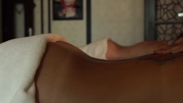 Женский массаж спины с маслом в роскошном спа-салоне. Молодая женщина получает массаж тела в салоне красоты и спа-центре. Отдых и уход за кожей . — стоковое видео