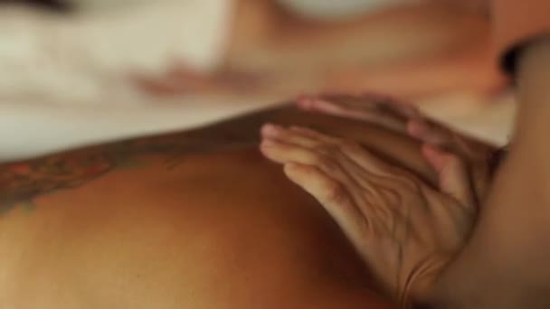 Massagem corporal e conceito de spa. Mulher com tatuagem nas costas recebendo massagem de óleo no salão de beleza. Jovem relaxante no centro de spa. Relaxamento corporal e cuidados com a pele — Vídeo de Stock