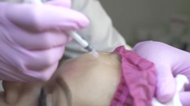 Handof güzellik uzmanı yüzüne güzellik enjeksiyon yapma kapatın. Genç kadın botox enjeksiyon tedavisi anti-aging alma. Anti kırışıklık ve cilt bakımı. Kozmetik kavramı. Plastik Cerrahi Kliniği.
