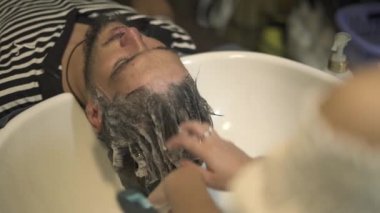 Kuaför el yıkama erkek Merkez şampuan kuaför dükkanında. Kuaför Salonu kafasından bulaşık kapatın. Erkek kuaför saç istemciye yıkama. Erkek saç bakım kavramı.