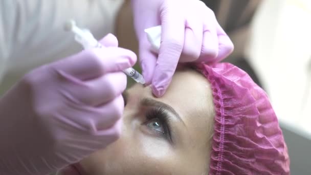 Kosmetyczka robi kosmetycznych wstrzykiwań na zmarszczki na czole w klinika urody. Zbliżenie twarzy kobieta podczas wtrysku piękno w kosmetycznych clinic. Odmładzanie, wstrzykiwania kosmetologii i medycyny pojęcie. — Wideo stockowe