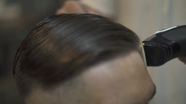 Friseur mit Kamm und Elektrorasierer zum Haarschneiden im Friseursalon. männliche Frisur mit Rasiermesser aus nächster Nähe. Friseur mit Trimmer für männliche Frisur. — Stockvideo