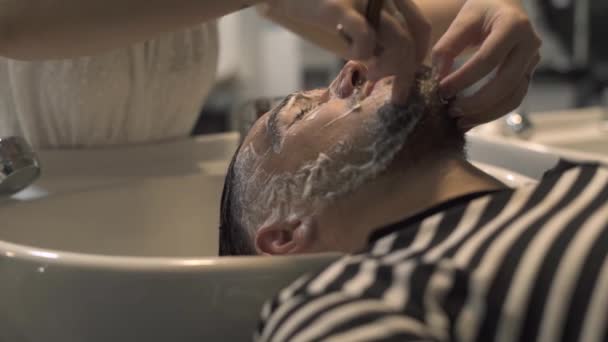 Barba de barbear macho com navalha reta na barbearia fechar. Barbeiro barbeando homem barbudo no salão masculino. Conceito de estilo Hipster barba . — Vídeo de Stock