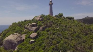 Yeşil dağlar ve kayalık sahil dron görünümü deniz feneri. Dağ cliff ve turkuaz deniz manzara ışık şirketten havadan görünümü.