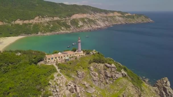 在悬崖边的轻型房子与美丽的海景景观鸟瞰。无人机查看海灯塔在山和蓝色水在天际风景. — 图库视频影像