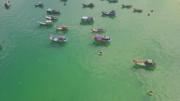 Statki rybackie i łodzie żaglowe na parkingu w wodzie błękitne morze w pobliżu piaszczysty brzeg z lotu ptaka. Krajobraz z latanie drone morze łodzie i statki w turkusowej wodzie. — Wideo stockowe