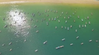Teknelerden ve mavi denize yakın kıyı havadan görünümü ayakta gemi. Balıkçı tekneleri ve deniz bağlantı noktası dron görünümünde gemiler yelken.
