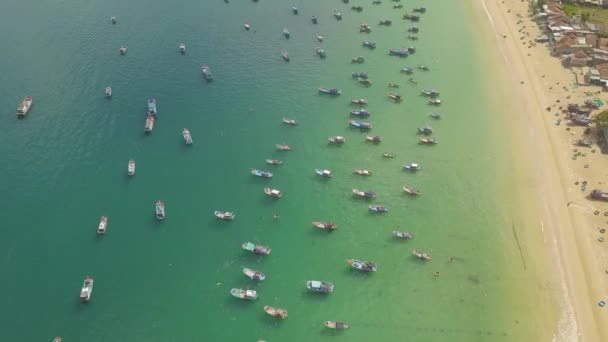 Fischerboote und Segelboote in blauem Meerwasser in der Nähe sandiger Küstenlandschaft. Seeboote und Segelschiffe im Drohnenblick. — Stockvideo