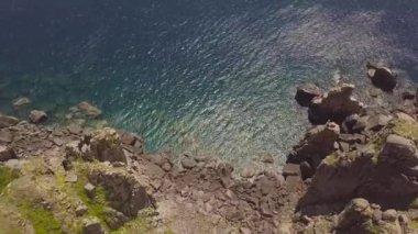 Kayalık uçurum kıyı ve mavi deniz uçağı görünümünde. Üstten görünüm uçurumun dağ ve turkuaz okyanus su. Drone kayalık deniz kıyısında uçan manzara.