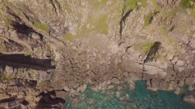 Drone görünümü kayalık uçurum ve mavi deniz suyu. Yeşil dağ cliff ans hava manzara deniz feneri deniz Yelkenli Gemiler.