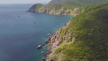 Yeşil dağ kayalık uçurum ve mavi deniz hava görünümünde yelkenli gemi ile. Drone dağ cliff ve mavi deniz manzarası üzerinde güzel manzara.