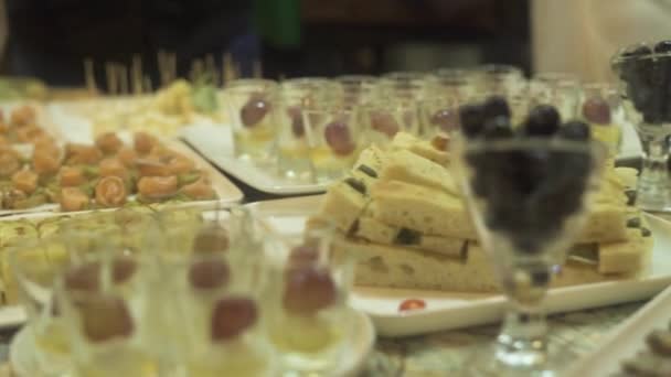 Snack e tartina sul tavolo del buffet all'evento. Snack appetitosi sul tavolo del partito alla sera di festa . — Video Stock