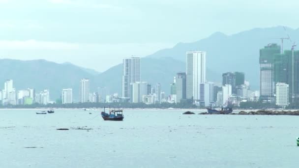 Panoramic view modern city by sea shore on mountains landscape. Ships and boats floating in sea. Skyscrapers building in city landscape. — Stock Video