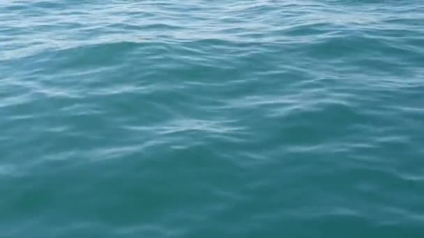青い海面をクローズ アップ。水表面に柔らかい海の波。ターコイズ ブルーの深い水海を背景. — ストック動画