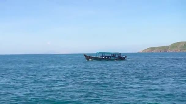 Navire flottant en mer bleue sur paysage de montagne, vue de bord. Bateau naviguant dans l'eau de mer turquoise, montagne verte et ciel clair à l'horizon . — Video